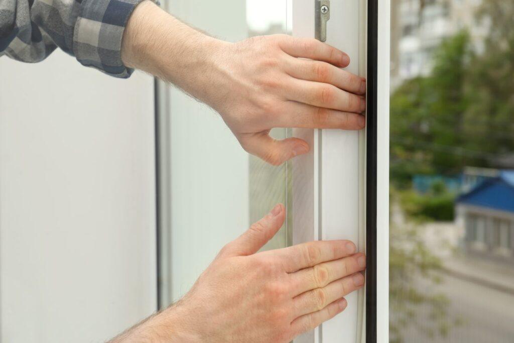 Dachsanierung beginnt mit Luftdichtheit – Haende pruefen Fensterrahmen auf Zugluft und Dichtheit