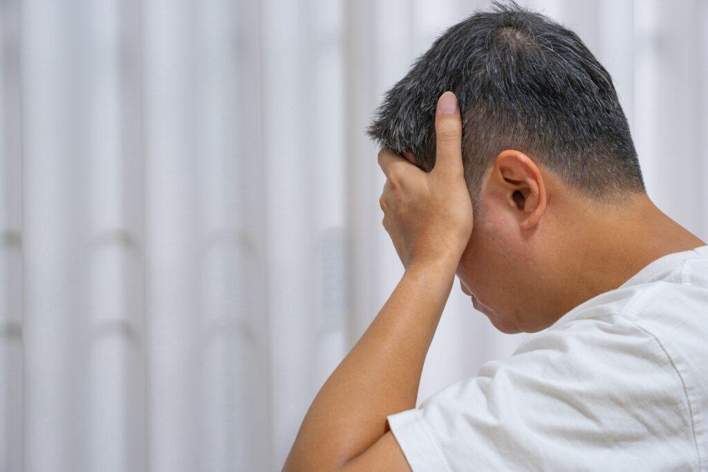 Mann mit Kopfschmerzen und Anspannung im Alltag | Pflege Jobs Frankfurt
